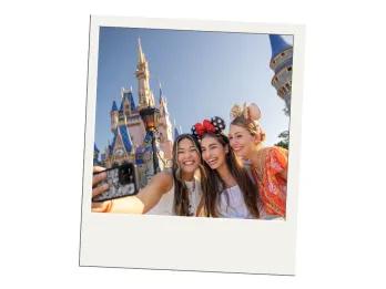 Three young women taking a selfie in front of Cinderella Castle