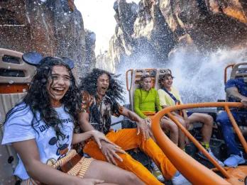 A group of friends getting splashed on a river raft ride