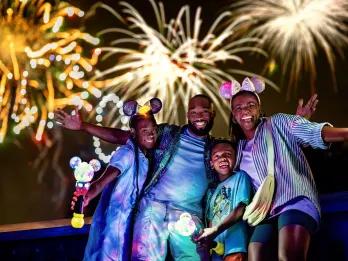 A family posing in front of a fireworks display