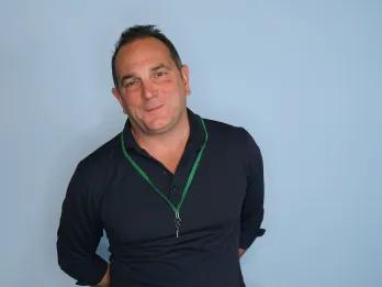 Man stood in front of a blue screen for a professional photo.