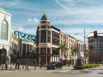Glamorous shops and restaurants lining the corner of a street. 