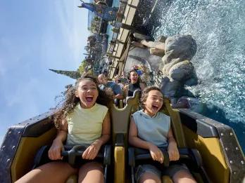 Two kids riding a rollercoaster over water