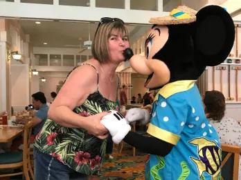 Sammie kissing Minnie Mouse on the nose in a character dining restaurant.