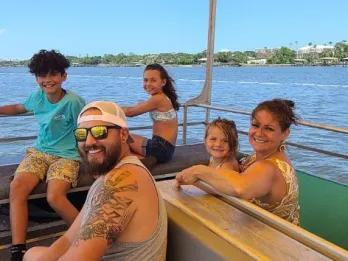 Happy family taking a scenic boat tour on the coastal waters of Daytona.