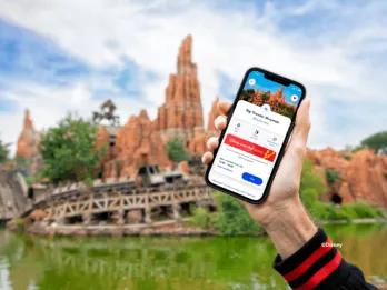 A person holding a phone up with Disney Premier Access on the screen