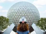A girl looking up at Spaceship Earth, a large geodesic sphere