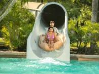 A couple on a raft coming out of a water slide