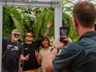 Tour guide taking a photo of three smiling people posing in a decorative frame during the Melbourne City Discovery Tour