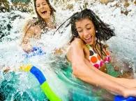 Two women smiling as they float along the River Rapids at Atlantis Dubai Aquaventure Waterpark