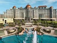 The impressive Universal Helios Grand Hotel with greenery in front of the hotel and a huge water fountain in the foreground