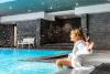Woman next to indoor pool at Relais Spa Val d'Europe 