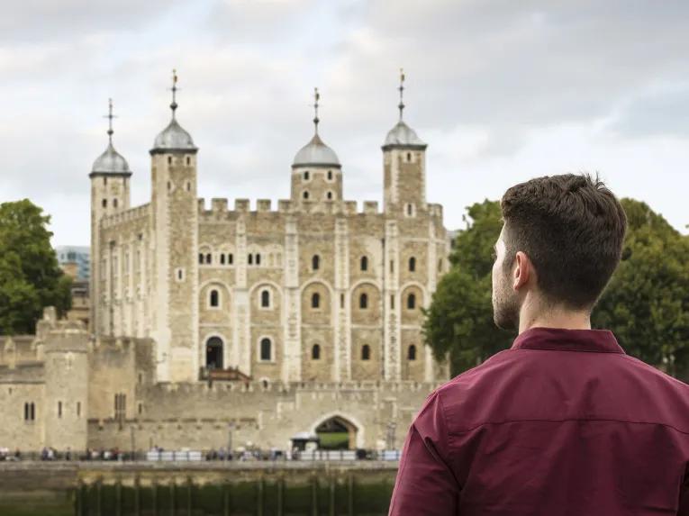 Man viewing Tower of London from across the river