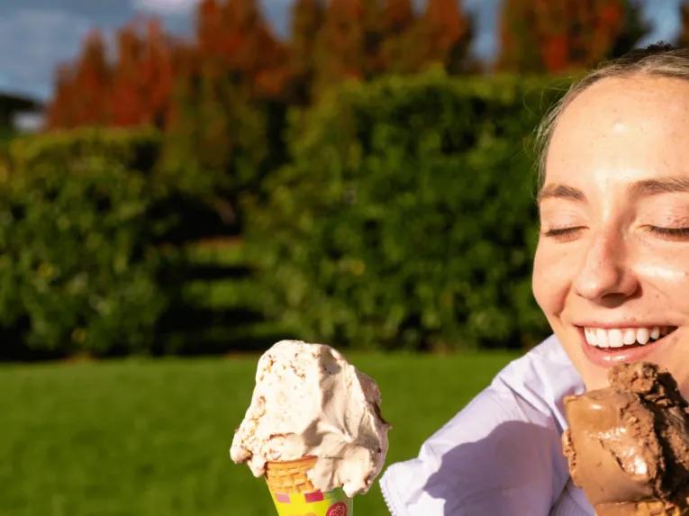 Happy woman holding two ice cream cones