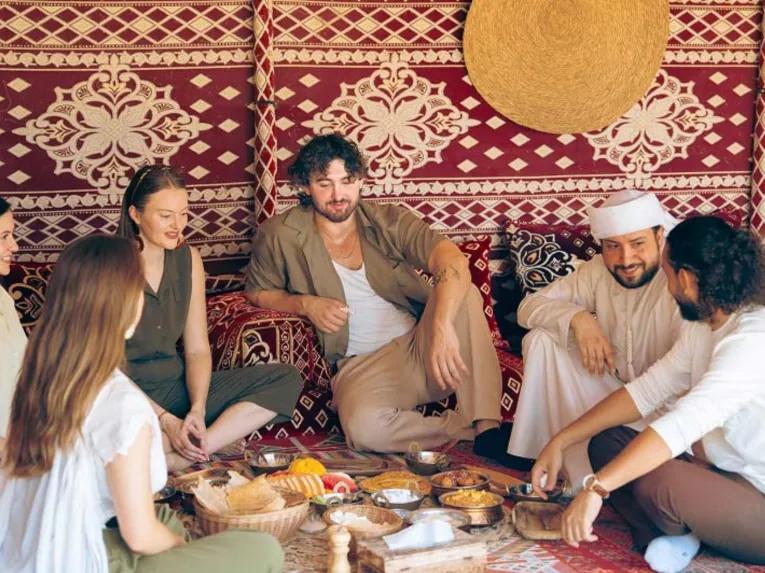 Guests enjoying traditional food and company during the Bedouin Culture Safari in Dubai