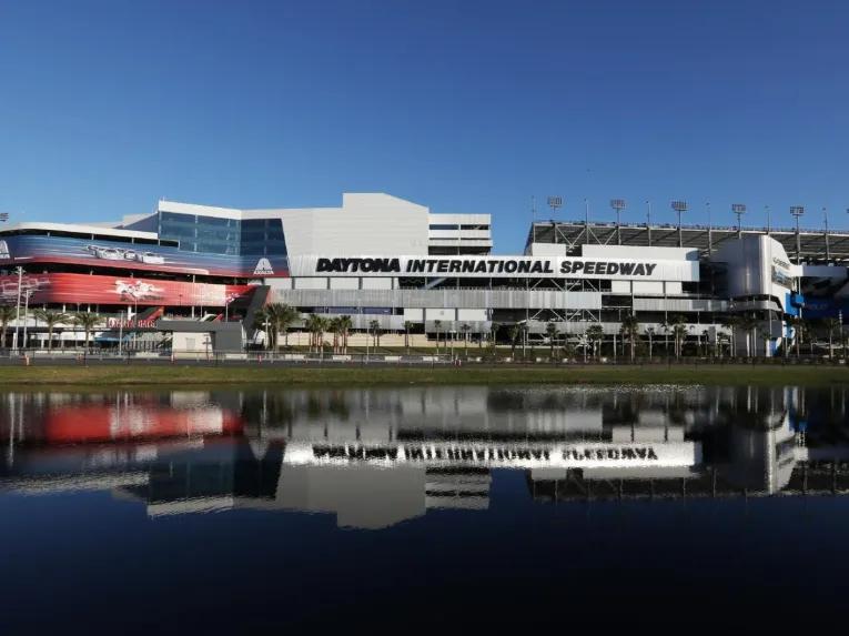 The exterior of Daytona International Speedway stadium with a clear water reflection